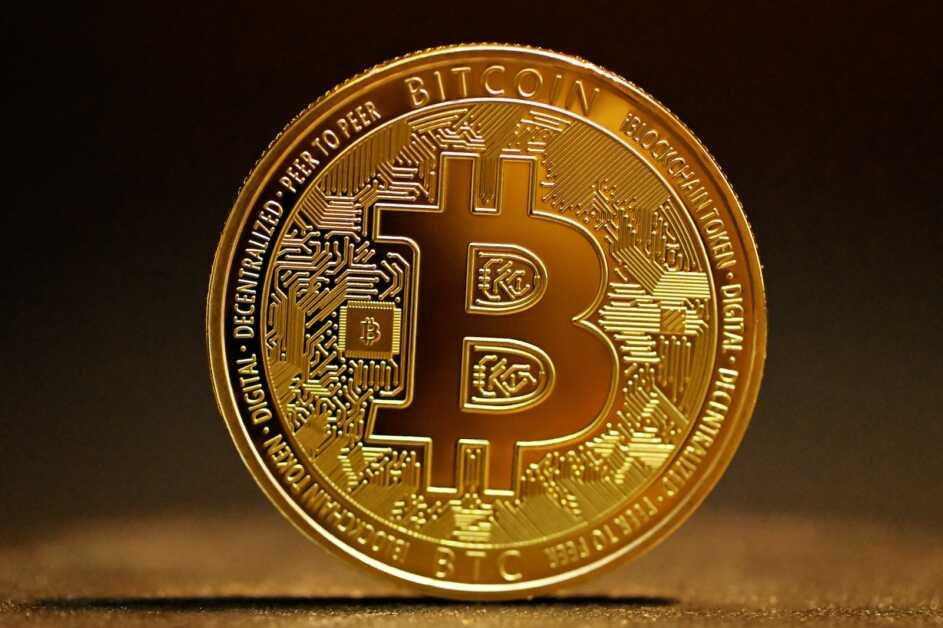 a golden bitcoin sitting on top of a table